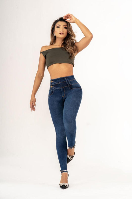 A woman modeling a pair of blue push-up jeans with a wide-rise fit and side buttons, and a green off-shoulder top.