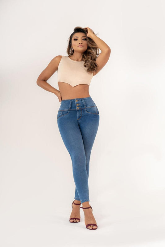 A female model wearing a beige crop top and blue push-up jeans with a high waist and three front buttons.